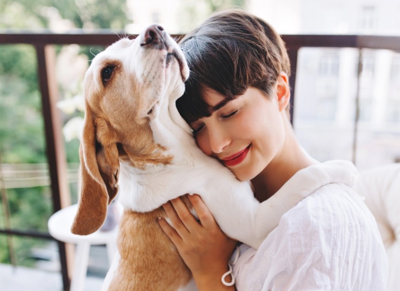 Tutora abraçando seu cachorro com carinho